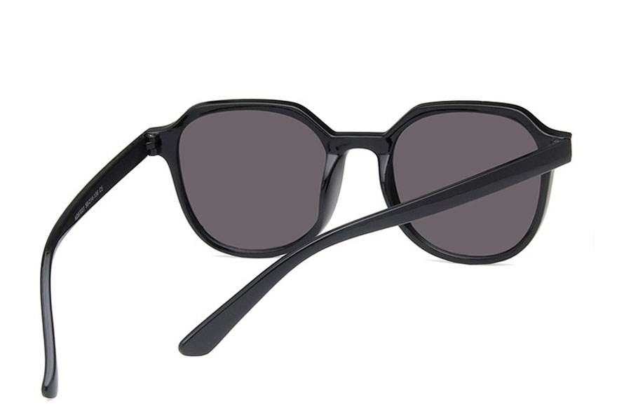 Dame solbrille i blank sort stel med grå-sorte glas. Formen er både lidt firkantet med runde former og rundt med kantede former | runde_solbriller-3